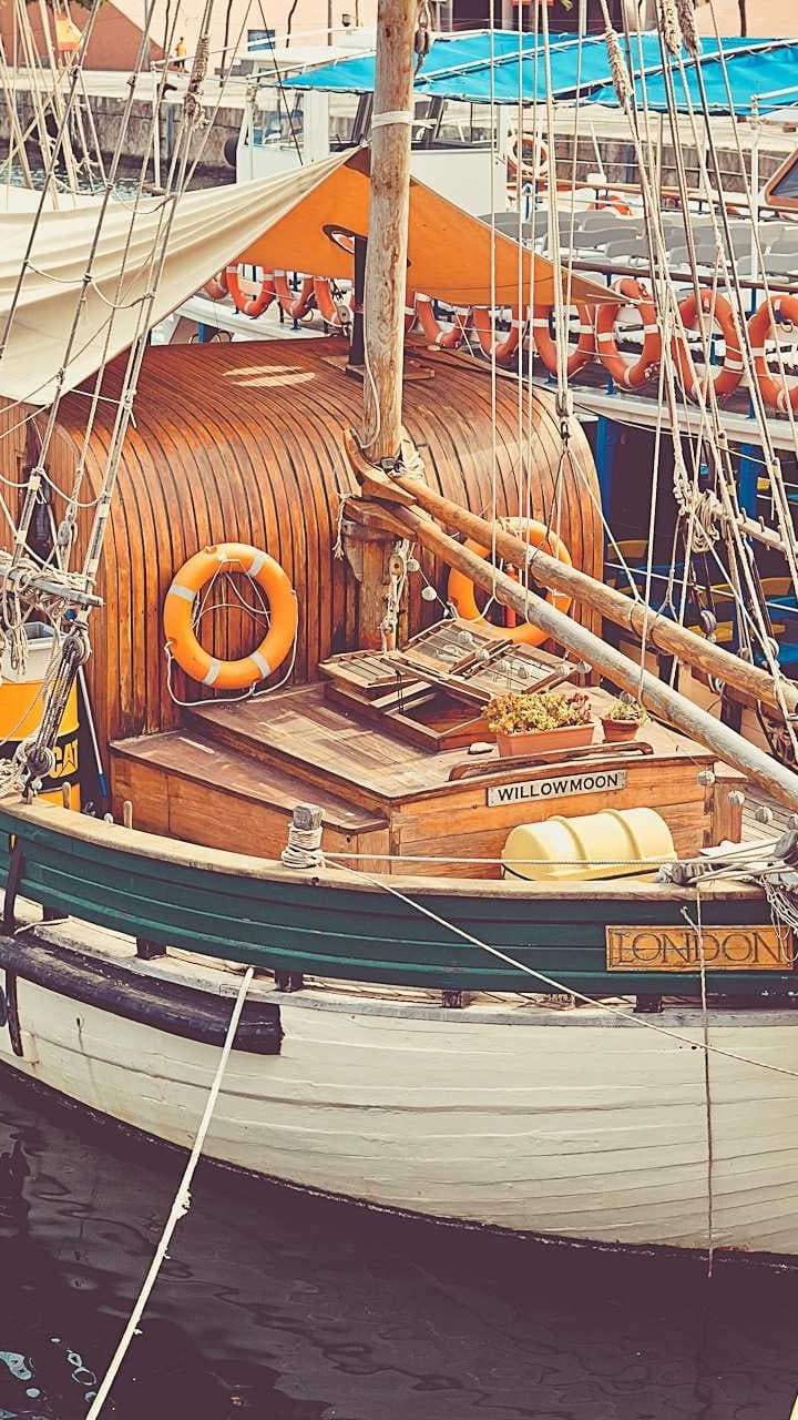 A wooden tour boat moored at a harbour wall